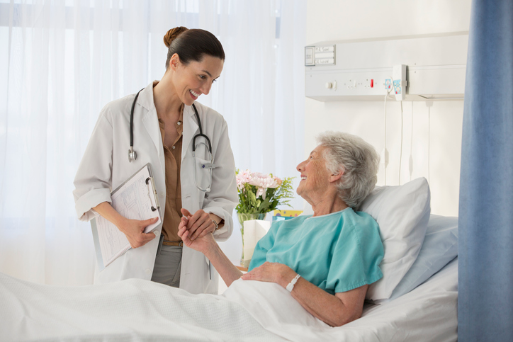 doctor holding a patient's hand in a hospital setting