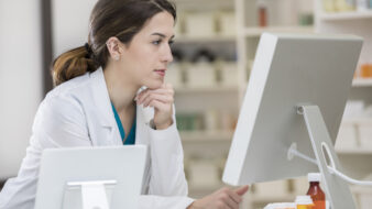 female pharmacy employee looking at computer screen