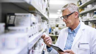 pharmacist looking at a medication in the community pharmacy stock room