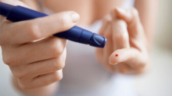 woman using a lancelet on her finger