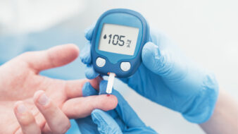 doctor checking blood sugar level with glucometer