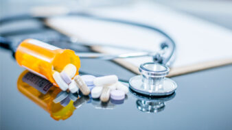 prescription bottle and stethoscope on a desk