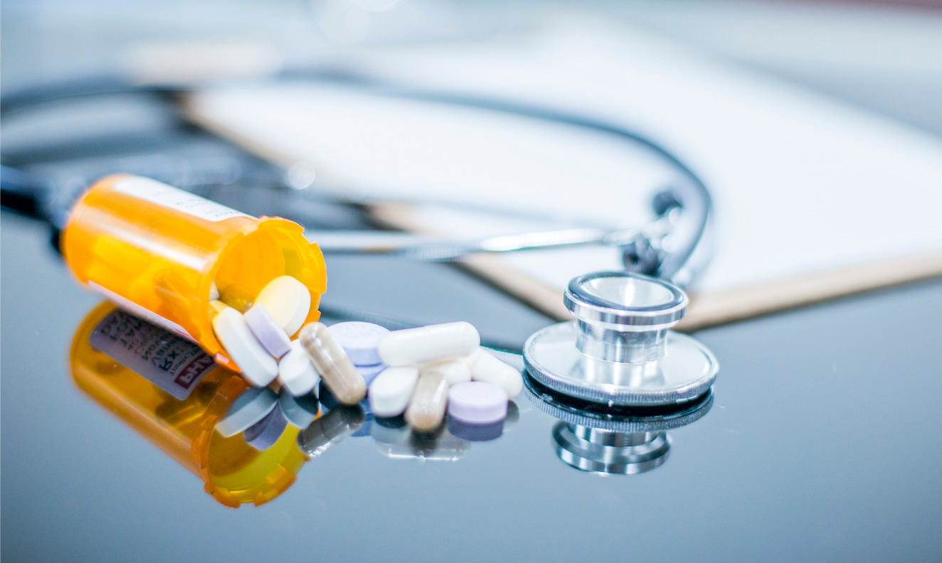 prescription bottle and stethoscope on a desk