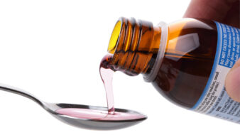 cough syrup being poured on a spoon
