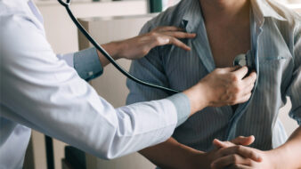 doctor listening to a male patient's heart with a stethoscope