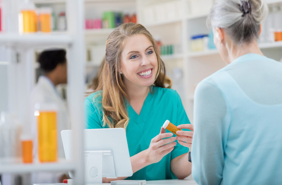 female technician talking to customer in pharmacy