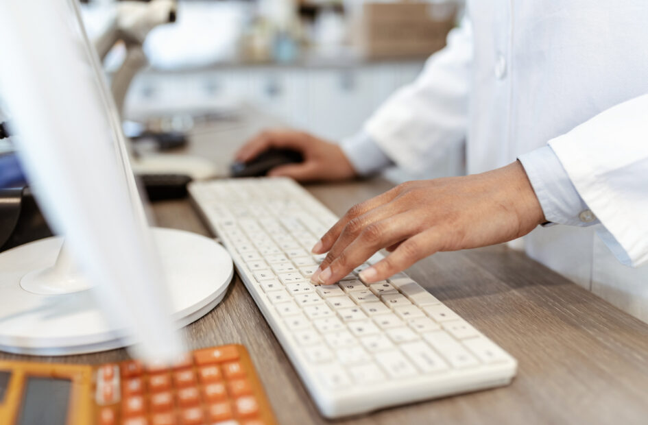 doctor typing on computer while standing
