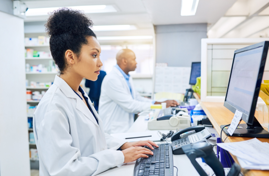retail pharmacist working on a computer checking legislative tracking