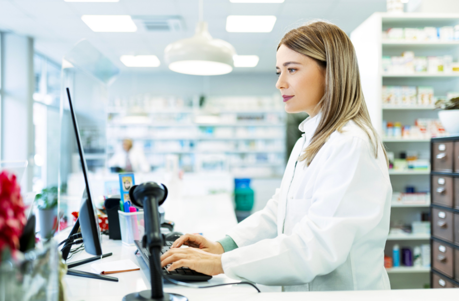 retail pharmacist working on a computer