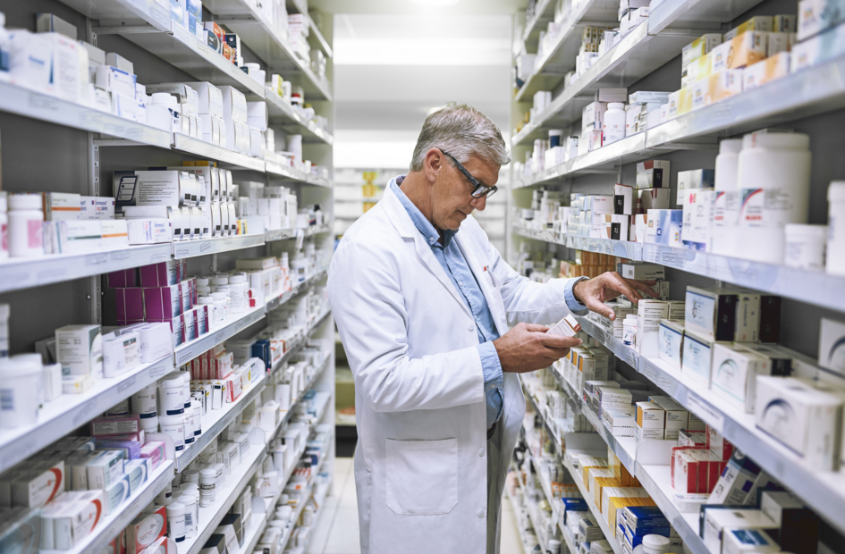 retail pharmacist checking medication in a pharmacy stock room