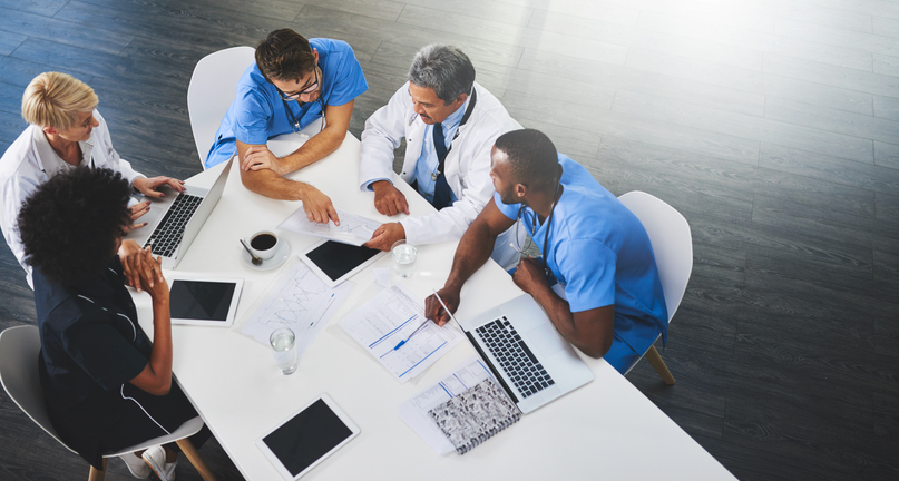 healthcare team sitting at a table discussing patient care