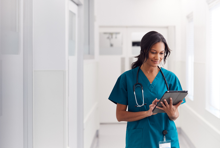 nurse looking at resources for APRNs on a tablet device in a hospital