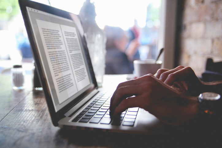 Person typing a paper on laptop