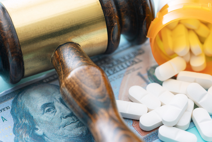 close up of judge gavel, pills, and money