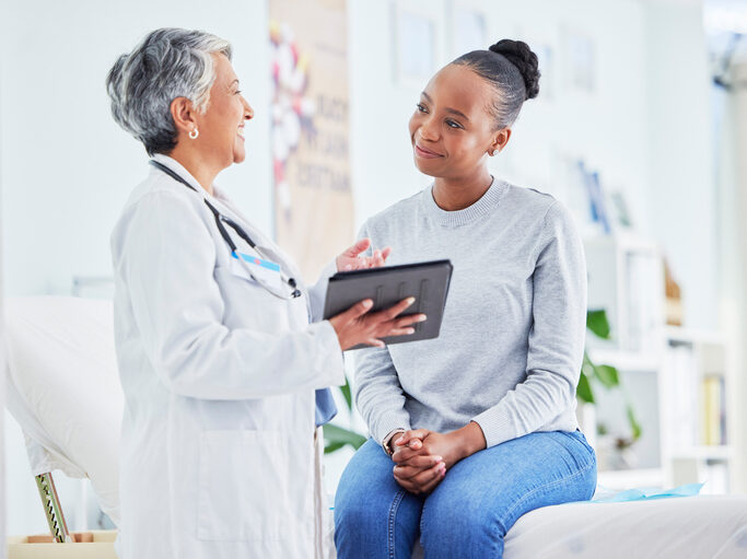 Nurse Practitioner Using Point of Care Tool with Patient