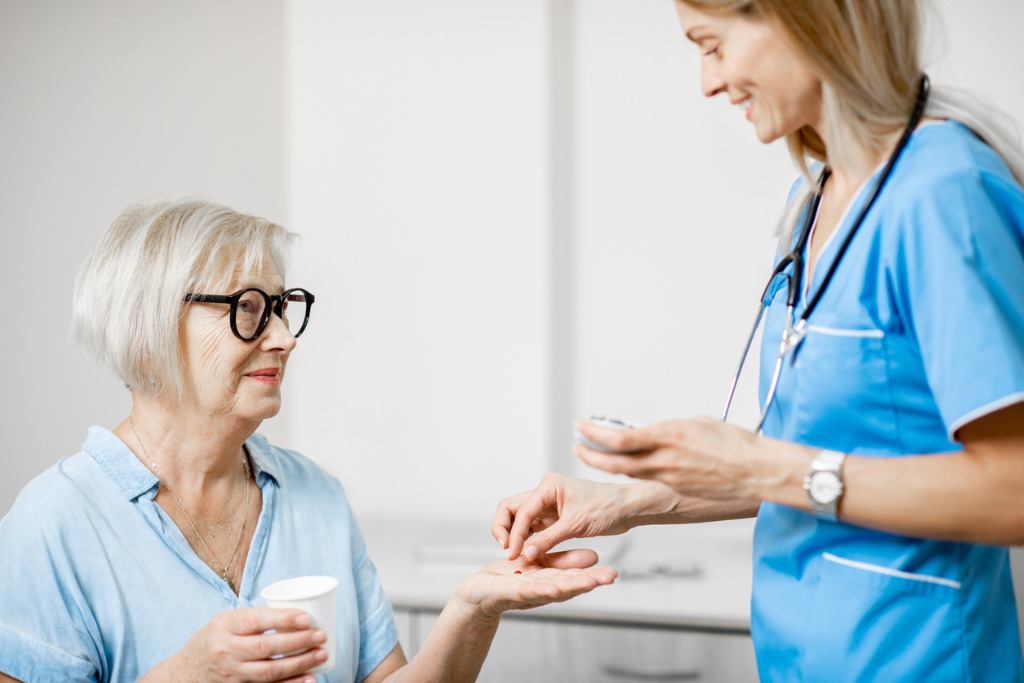 Nurse practitioner giving medication to patient
