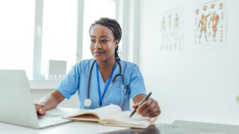 female nurse working on her computer and taking notes