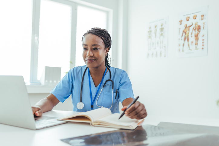 female nurse working on her computer and taking notes